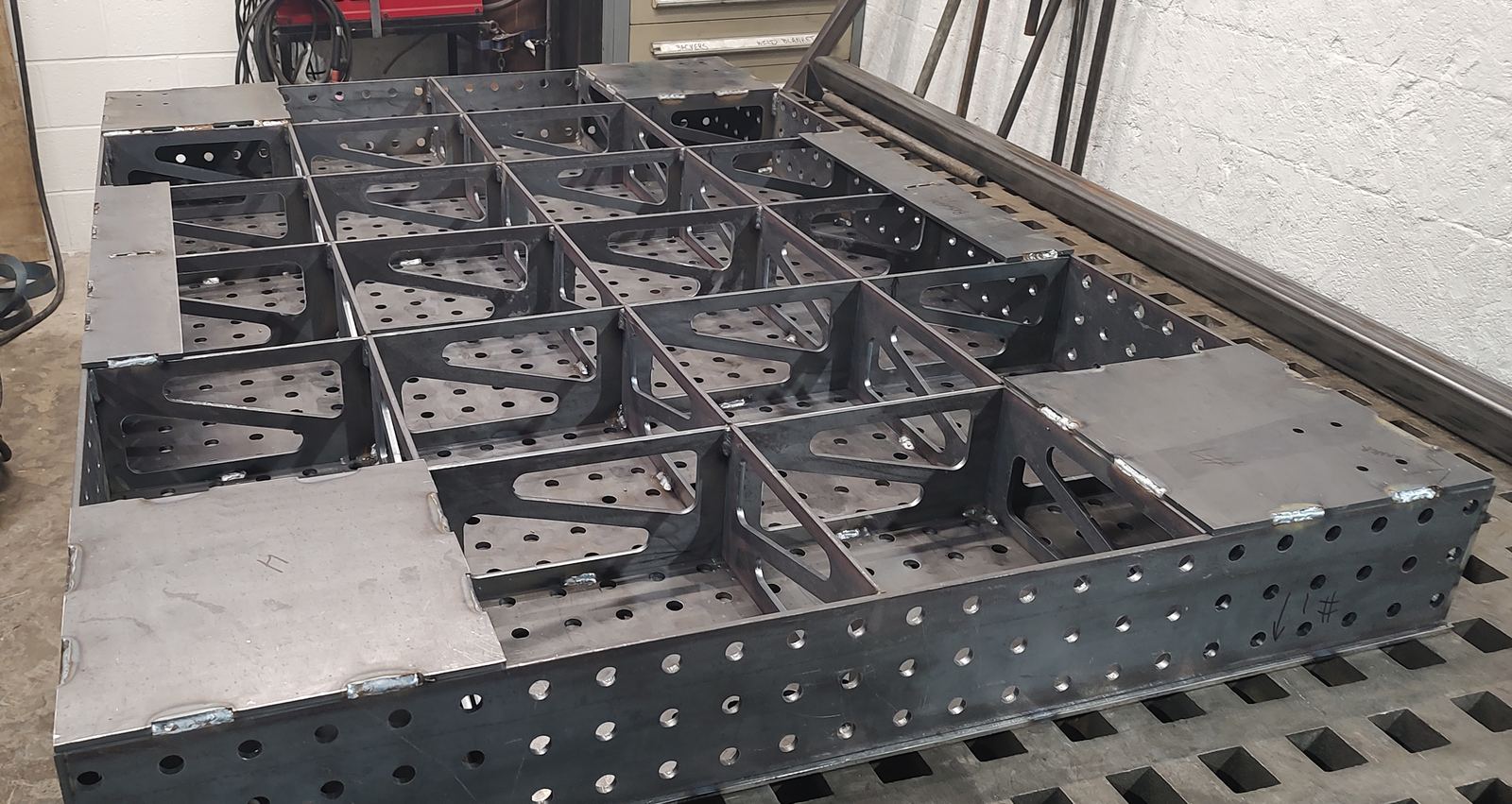 Laser-cut interlocking ribs and corner plates beneath the welding table